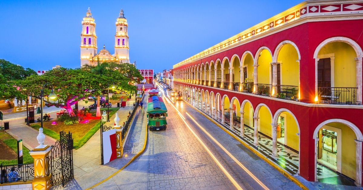The illuminated arcades and cathedral of a colonial Yucatán city at dusk