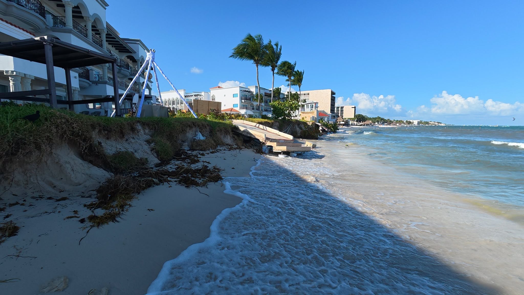 An eroded sand bank below beachfront hotels at Playa Constituyentes, Playa del Carmen