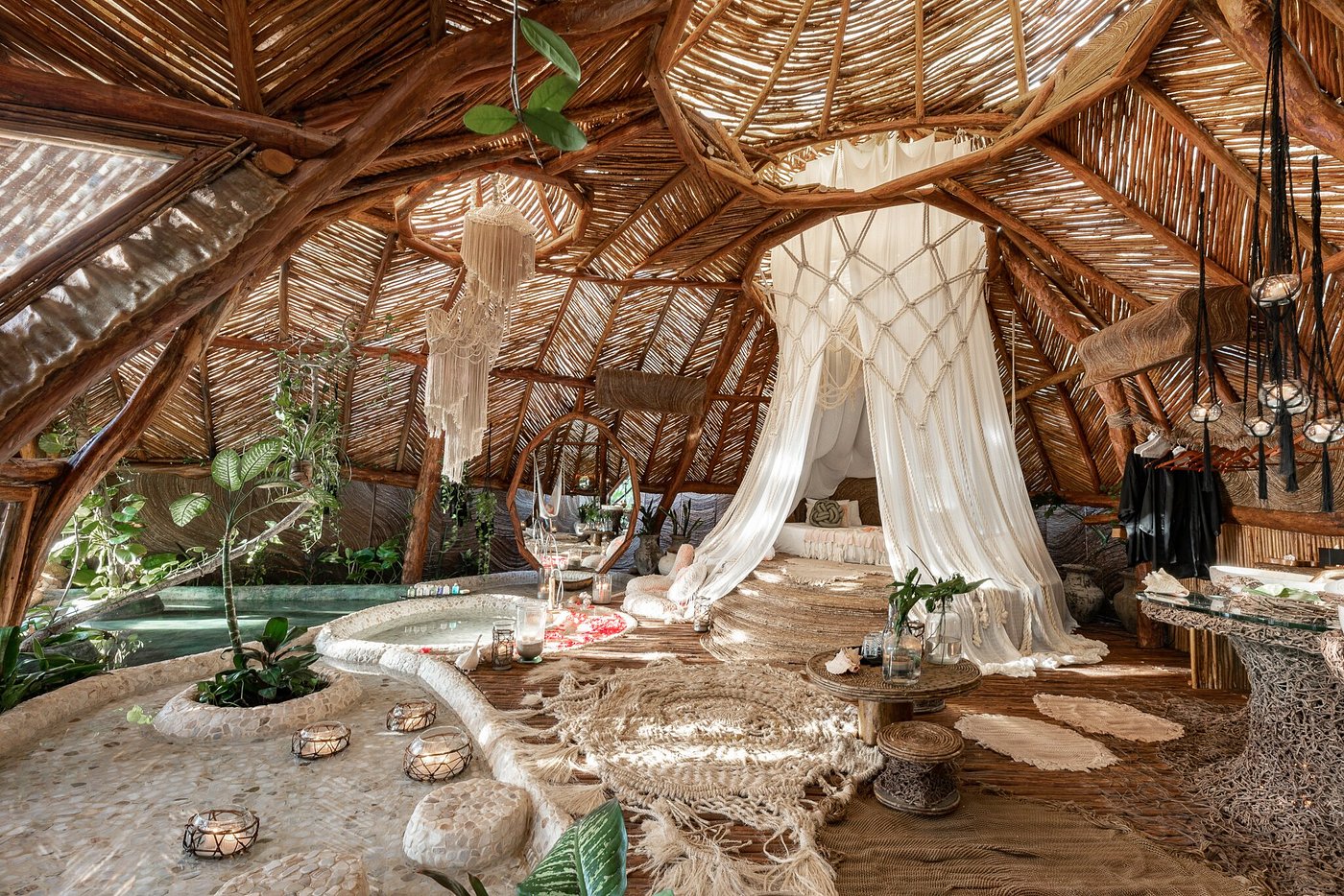 A domed villa interior of woven wood with a macramé bed canopy and private plunge pool at Azulik Tulum