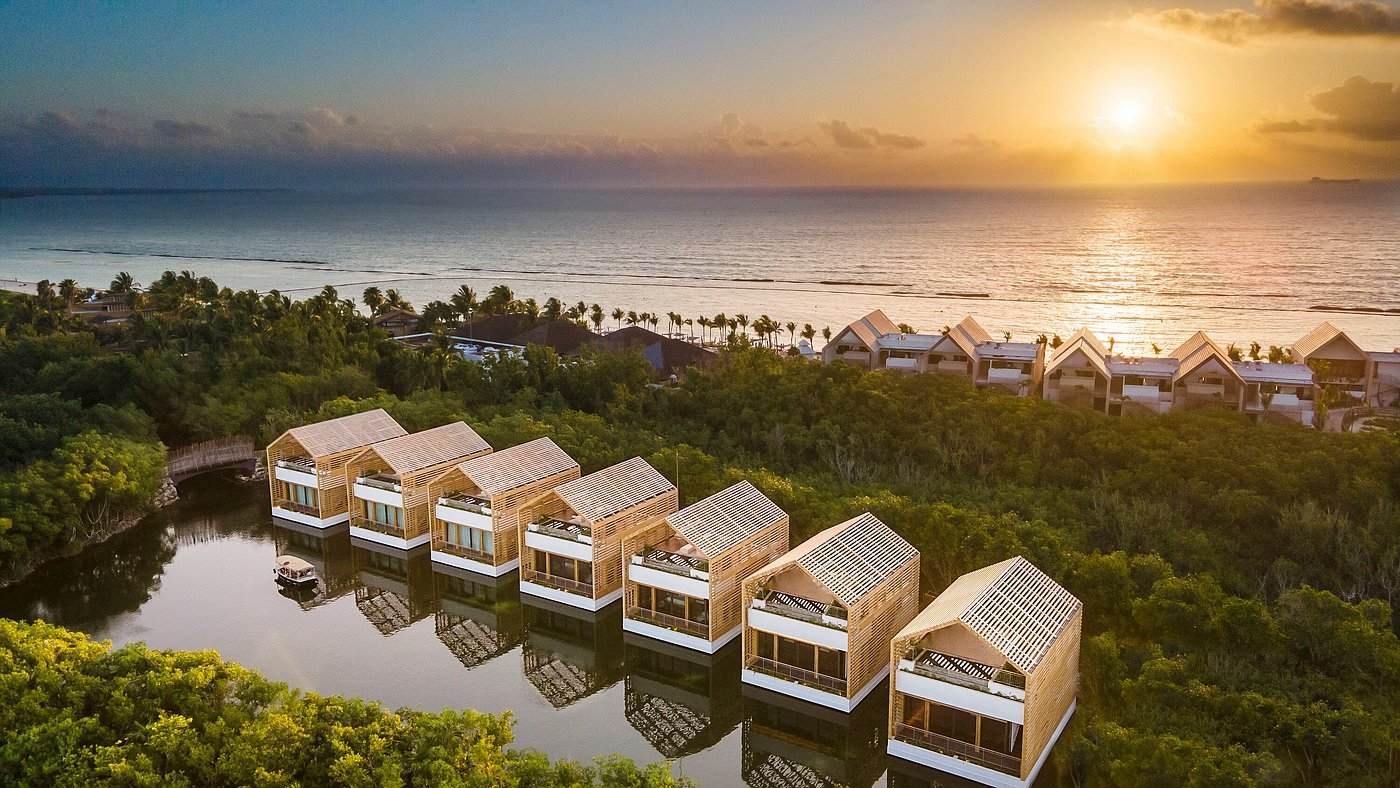 A warmly lit villa terrace and bedroom opening onto a private deck at night, Banyan Tree Mayakoba