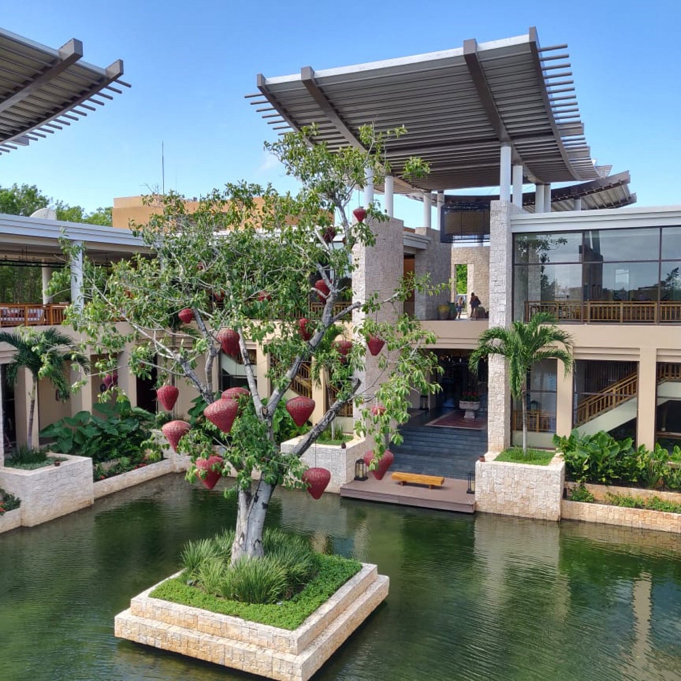 Pitched-roof lagoon villas at Banyan Tree Mayakoba glowing at sunset over calm water