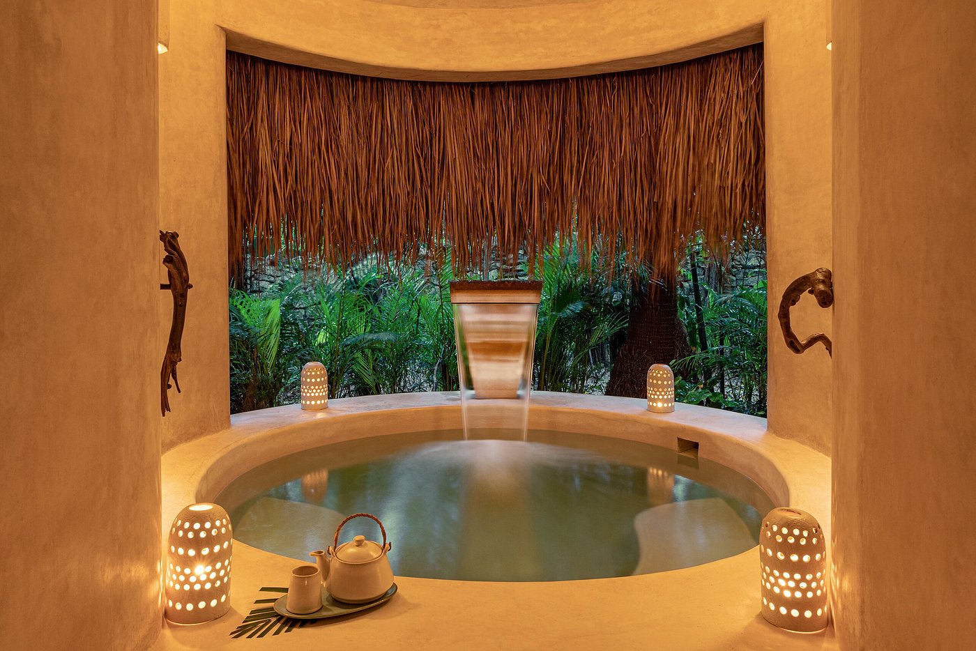 A whitewashed rooftop plunge pool and shaded lounge overlooking endless jungle canopy at Hotel Esencia