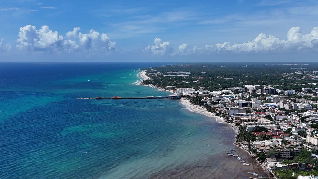 Aerial view of the Cozumel ferry pier at Parque Fundadores, with turquoise water and the town behind