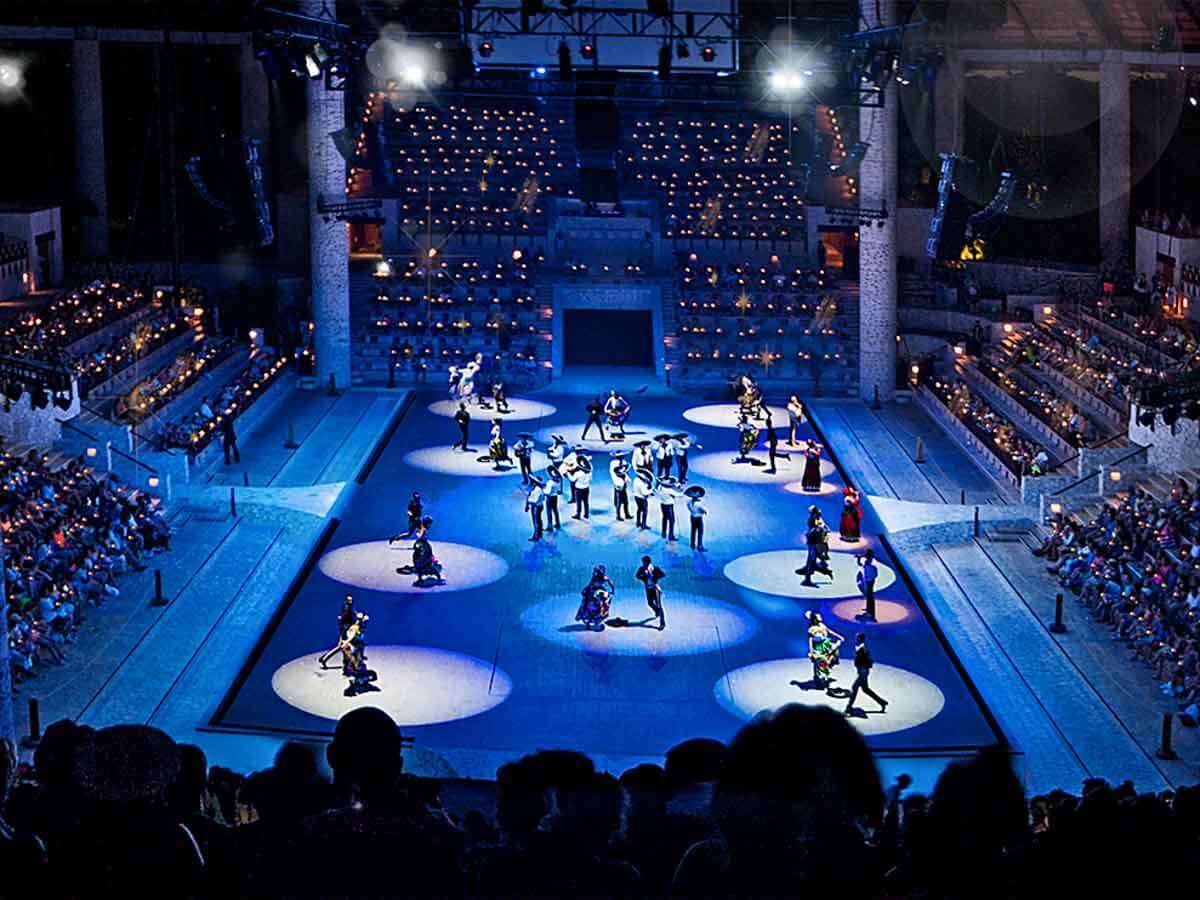 The grand evening show at Xcaret, with performers in colorful costumes under stadium lighting